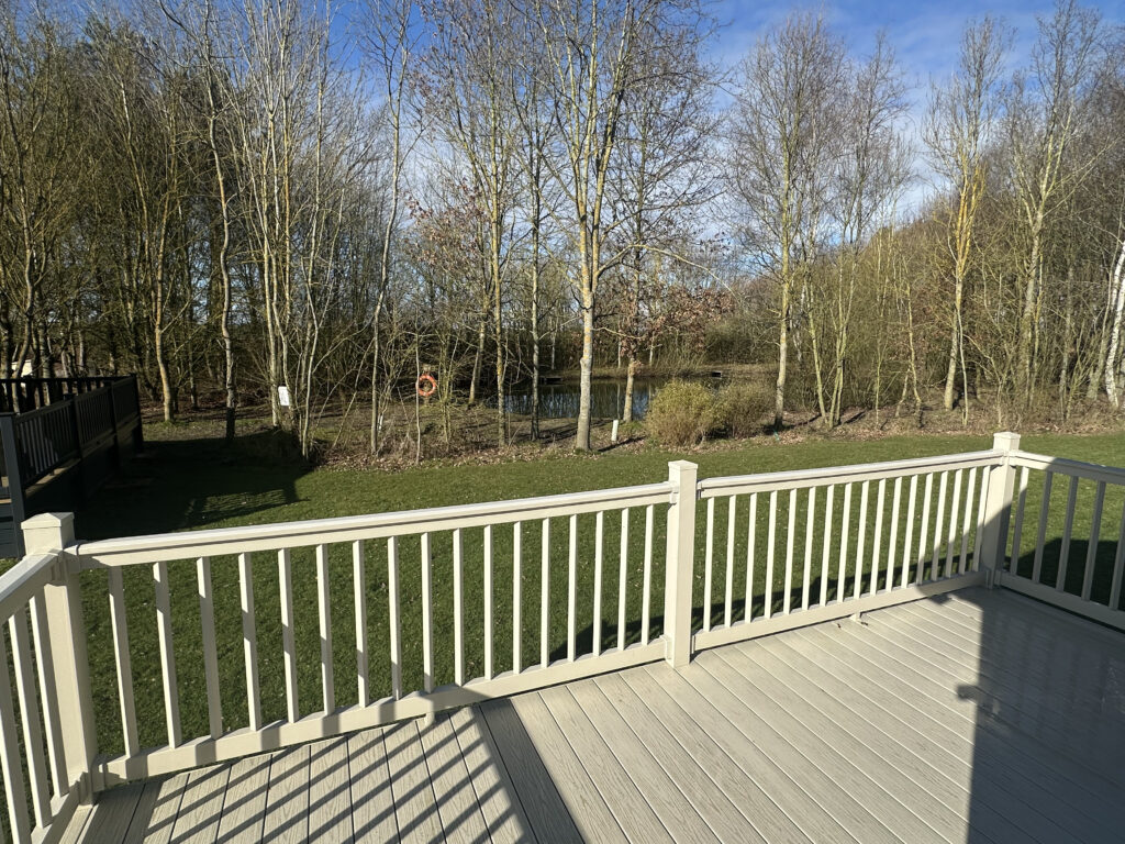 Lodge decking looking across the lawn to the owners-only fishing lake at Epworth Fields