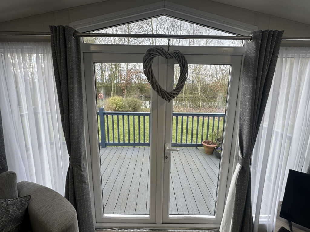 French doors opening onto the private deck of a lake-view lodge for sale at Epworth Fields
