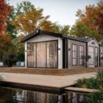 Willerby Vogue holiday home exterior with triple sliding patio doors and wide decking among autumn trees