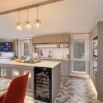 Willerby Vogue kitchen with an island, induction hob, handleless cabinets and pendant lights over the island