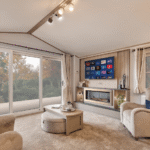 Willerby Vogue lounge with sliding patio doors, two armchairs and a panelled fire and media unit with wall-mounted TV