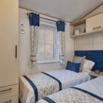 Willerby Vogue twin bedroom with two single beds, padded headboard, tall wardrobe and window